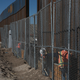 Photo of workers raising a taller fence in the Mexico-US border separating the towns of Anapra, Mexico and Sunland Park, New Mexico via AP